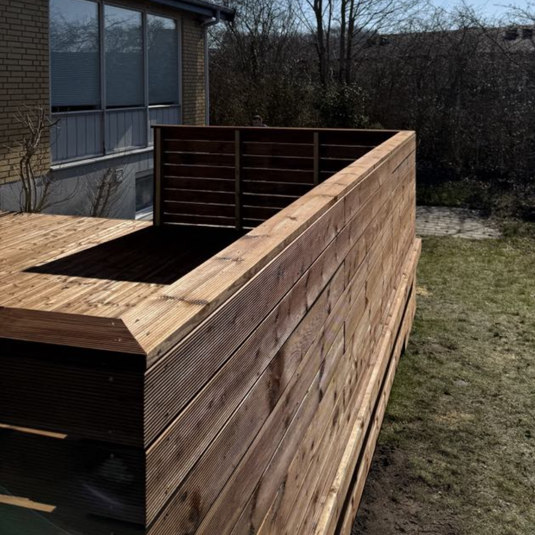 Hegn på brunimprægneret træterrasse i Nordjylland